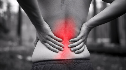 close up photo of a person holding a sore back