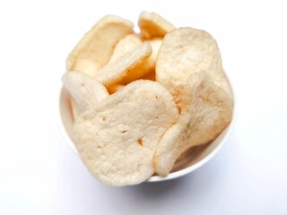 A pile of shrimp crackers in a small bowl. Shrimp crackers are made from a mixture of tapioca flour and finely pounded shrimp with spices and flavor enhancers. A snack from Sidoarjo, Indonesia.