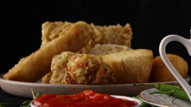 close up on dipping fried tofu or tahu goreng in the spicy sauce with a black background. famous Indonesian snack
