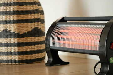 Modern electric infrared heater in living room, closeup