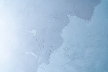 The texture of a concrete wall with applied decorative plaster or microcement. Part of the micro-cement has been applied and is still wet. A template for your product or text