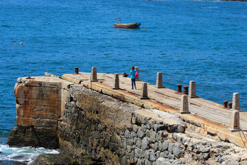 turista visitando el muelle de la ex ballenera ubicada en bahía Quintay, Valparaíso, Chile