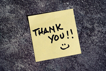 Thank you written on a post-it or note.