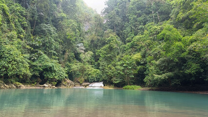 Natural scenery: trees, waterfalls, sky and blue-green river water