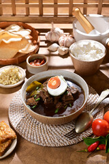 Rawon is a traditional Indonesian beef soup with a rich, black broth made from keluak nuts,...