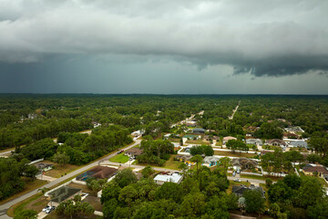 Landscape of dark ominous clouds forming on stormy sky before heavy thunderstorm over rural town...