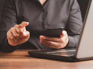 Close-up of a professional using smartphone and laptop.