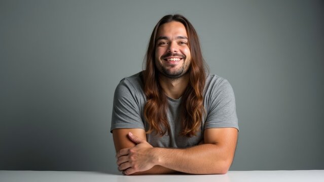 Smiling Man With Long Hair Embodies Confidence and Approachability in a Minimalist Setting