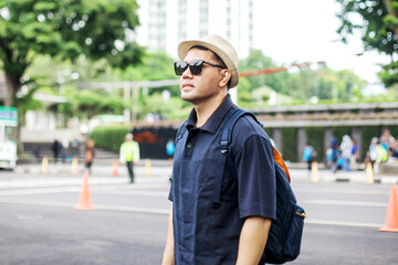 Tourist Asian Guy Wear Sunglasses Standing While Looking Away on Sidewalk