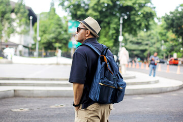 Asian Traveler Man Walking While Looking Away on Sidewalk