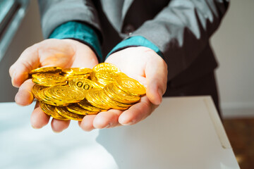 Close-up of a businessman holding shiny gold bars, symbolizing wealth and investment, isolated on a...