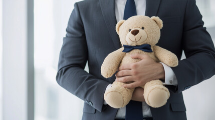 Businessman Holding Teddy Bear: A businessman in a suit holds a teddy bear close, a captivating image that speaks to the soft side of success.