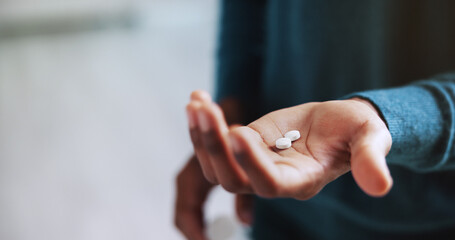 Person, hands and patient with pills for medication, pain relief or prescription at home. Closeup, pharmaceuticals or tablets with consumer for healthcare dosage, drugs or medical cure at house