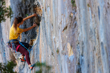  girl climbs a rock. rock climber girl. rock climbing as an Olympic sport.