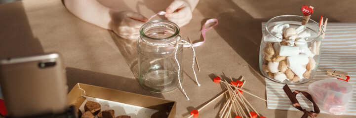 Children's hands collect a sweet gift for Valentine's Day. A gift for the holiday, a video blog entry. Demonstrating the colors of 2025 - Mocha Mousse