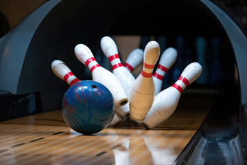 A bowling ball rolling down the lane, high-fiving pins as they fall