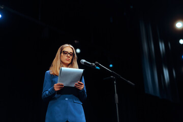 Woman Holding a Clipboard Ready to Deliver a Speech. Teacher speaking in public at a scientific...