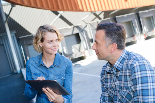female and male worker outside factory