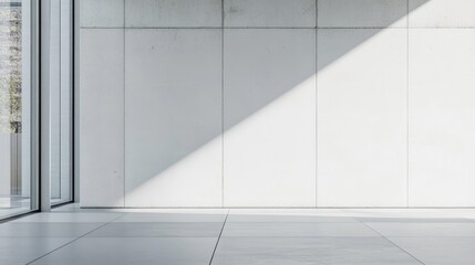 Obraz premium Modern minimalistic interior with white cement wall and natural light creating shadows in a spacious room design concept.