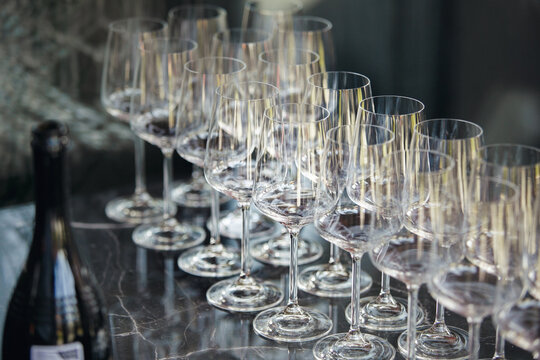 Lots of empty wine glasses on the bar, close up. Restaurant serving. - Powered by Adobe