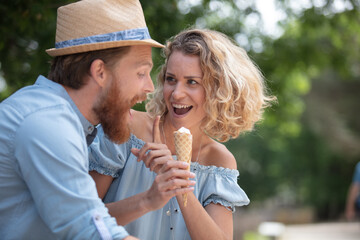 Fototapeta premium portrait of a happy couple talking and eating ice creams
