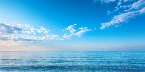 Obraz premium Serene calm sea against a backdrop of a beautiful blue sky, creating a perfect setting for relaxation. This calm sea and blue sky image captures tranquility and natural beauty.