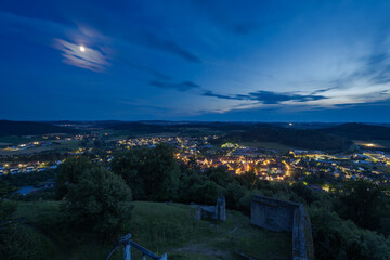 Scenic view over the castle ruin and the town Velburg in Bavaria, Germany at night with moon