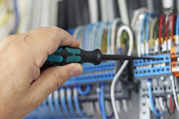 Installation of electrical wires using a screwdriver with an insulated handle.