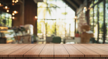 Empty wooden table top with lights bokeh on blur restaurant background.