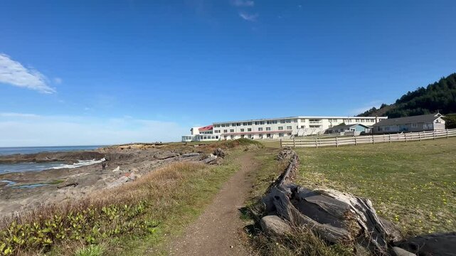Slow motion walkin of a wooden fenced path leading to the Overleaf Lodge and Spa, in Yachats Oregon.