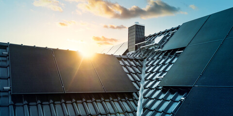 Modern home with solar panels on the roof at sunset