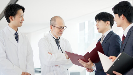 話をする医者と営業職の男性