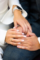 Wedding tradition: the hands of bride with engagement ring and groom  
