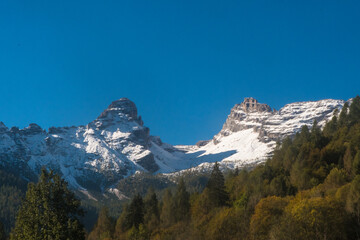 Fototapeta premium Panorama sul gruppo del Tàmer e del San Sebastiano in Val di Zoldo sulle Dolomiti bellunesi, coperto dalla neve in una giornata autunnale di sole 