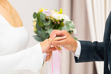 Wedding tradition: the bride is putting wedding ring for the groom  