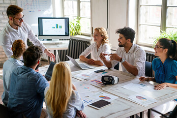 Group of young multi-ethnic startup business team collaborating on project in modern office