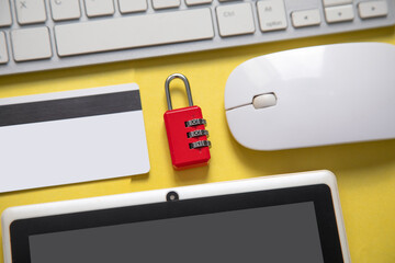 Padlock, credit card, computer keyboard on the yellow background.