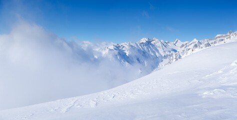 Obraz premium Winter mountain landscape. Wallpaper or background. Cold weather and frost. A place for skiing. Ski resort. High rocks and snow. View of mountains.