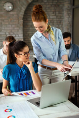 Fototapeta premium Business women entrepreneurs working in coworking space smiling, brainstorming as a team in office