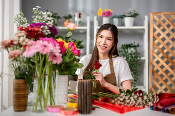 Portrait of florist woman completing beautiful bouquet in flower shop. 