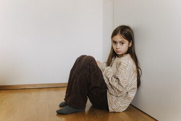 Photo of Expression of lonely female teenager sitting on the floor at home. Pensive teen....