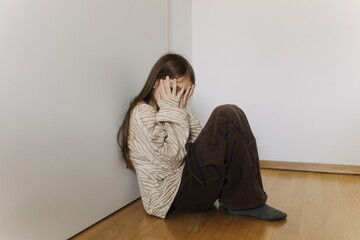 Photo of Expression of lonely female teenager sitting on the floor at home. Pensive teen....