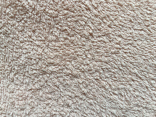 Soft and absorbent, light brown terrycloth fabric texture provides a cozy and inviting background,...