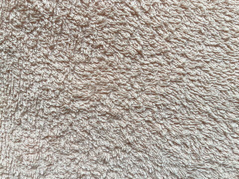 Soft and absorbent, light brown terrycloth fabric texture provides a cozy and inviting background, perfect for showcasing comfort, warmth, and relaxation