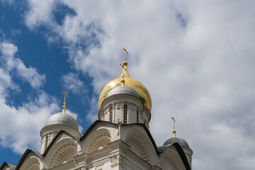 Golden domes of Orthodox cathedrals glow insun against blue sky. Snow-white Orthodox cathedrals are located on territory of Moscow Kremlin. Clear sunny summer day. Moscow, Russia – June 14, 2024