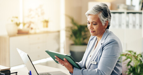 Woman, doctor and smile in office with tablet, online consultation and pleased with results at laptop. Mature specialist, tech and reading in practice for healthcare, telehealth and medical research