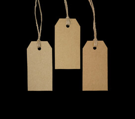 3 blank tags with twine on black background