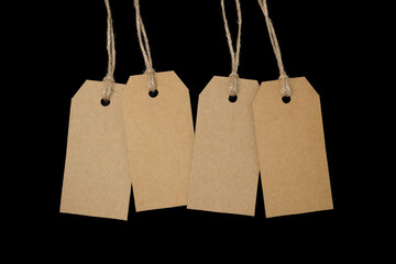 4 blank tags with twine on black background