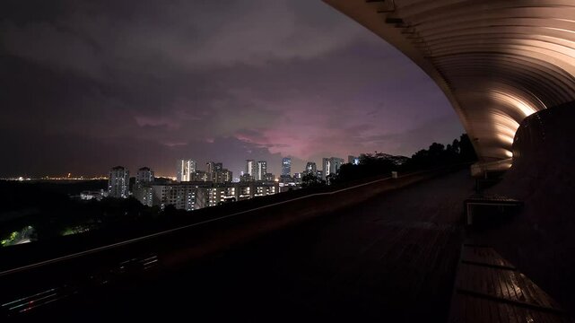 The Henderson Wave Pedestrian Bridge. View of Singapore's beautiful downtown at night.