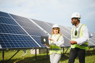 African american businessman and european female engineer talking near solar panels